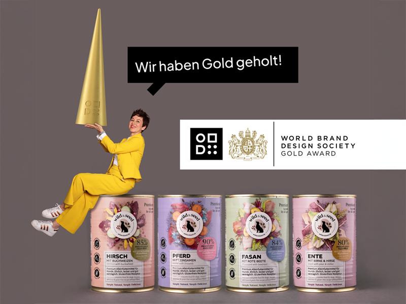 Kira Hädrich von 18Quadrat sitzt im gelben Anzug auf den Wild-&-Seed-Dosen und hält den WBDS Gold Award; daneben das Logo der World Brand Design Society und die vier prämierten Designs.
