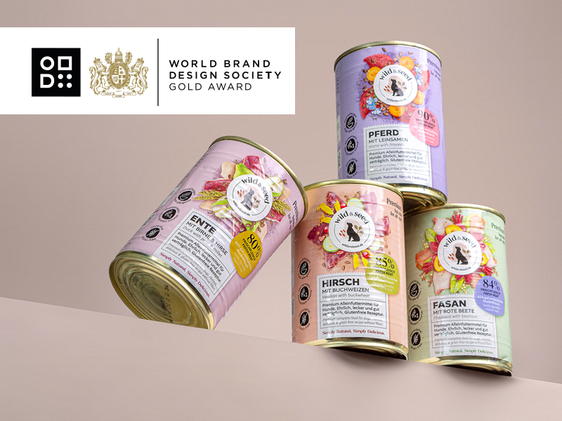 Vier Wild-&-Seed-Hundefutterdosen in floraler Gestaltung, designt von 18Quadrat, ausgezeichnet mit dem World Brand Design Society Gold Award; Sorten Hirsch, Fasan, Ente und Pferd, arrangiert vor rosa Hintergrund.